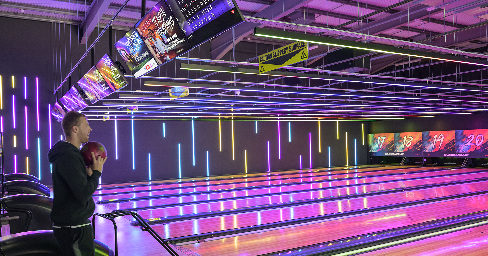 Tenpin bowling lanes lit up at night with neon lighting